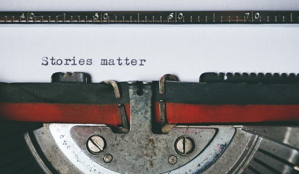 Close up photo of a typewriter with the words &#039;stories matter' printed on a page